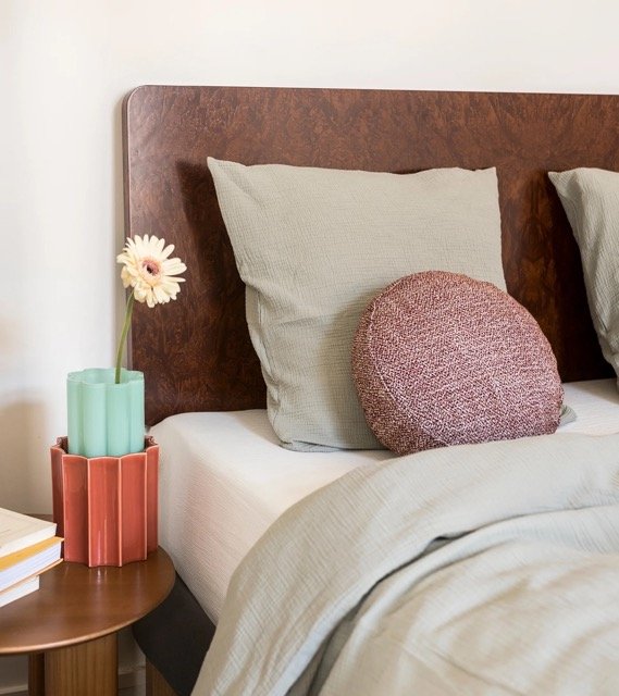 Chambre vintage chic avec tête de lit en loupe d’orme, tons naturels et décoration élégante.